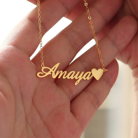 Gold necklace with 'Amaya' pendant held in a hand
